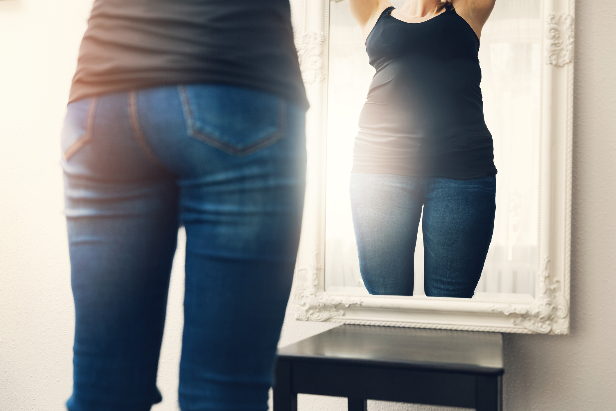 Una mujer se mira al espejo, pero se ve en un cuerpo diferente