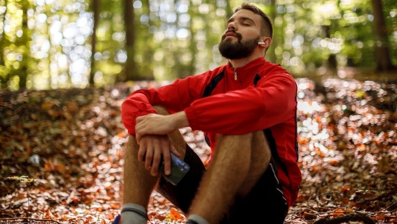 Hombre descansa de su rutina de ejercicio en un parque respira tranquilidad y es feliz